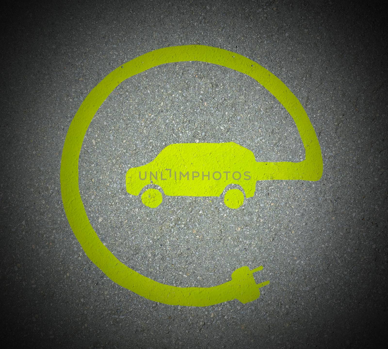 EV - electric vehicle charging station sign on asphalt. 'E' sign on asphalt texture. Image with dark corners frame