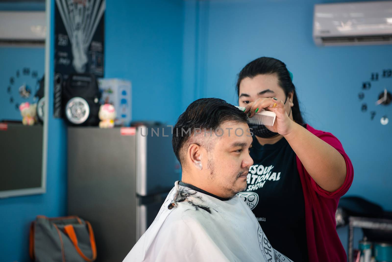 Bangkok, Thailand - February 2, 2020 : Unidentified asian man hairdresser or hairstyle haircut a man plump body customer in fashion hairstyle at barbershop
