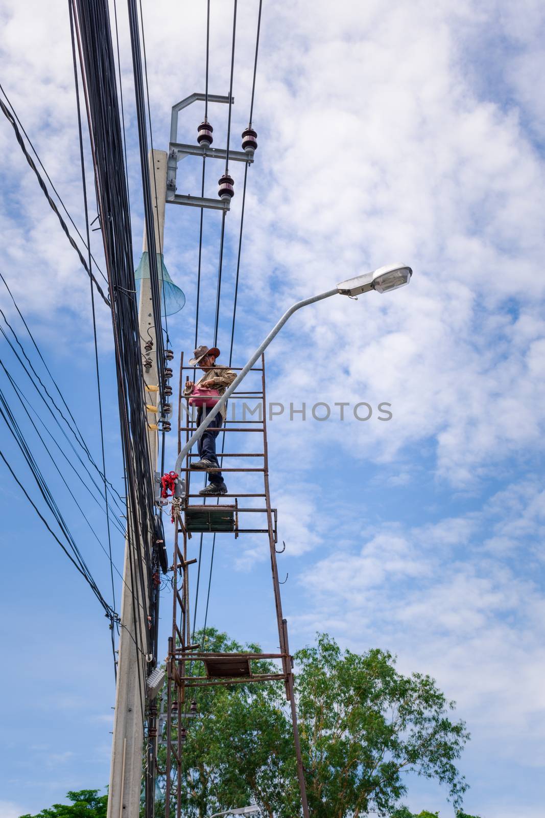 Electricians risk working install electric line by PongMoji