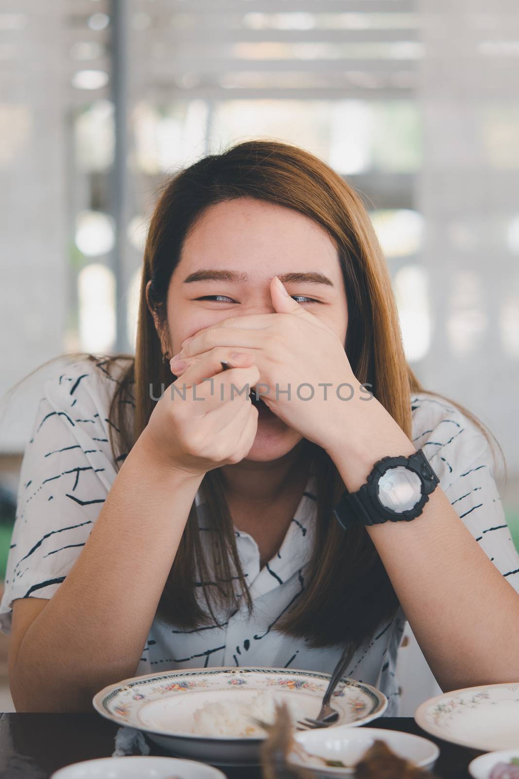 Woman eating food on dining table in restaurant by PongMoji