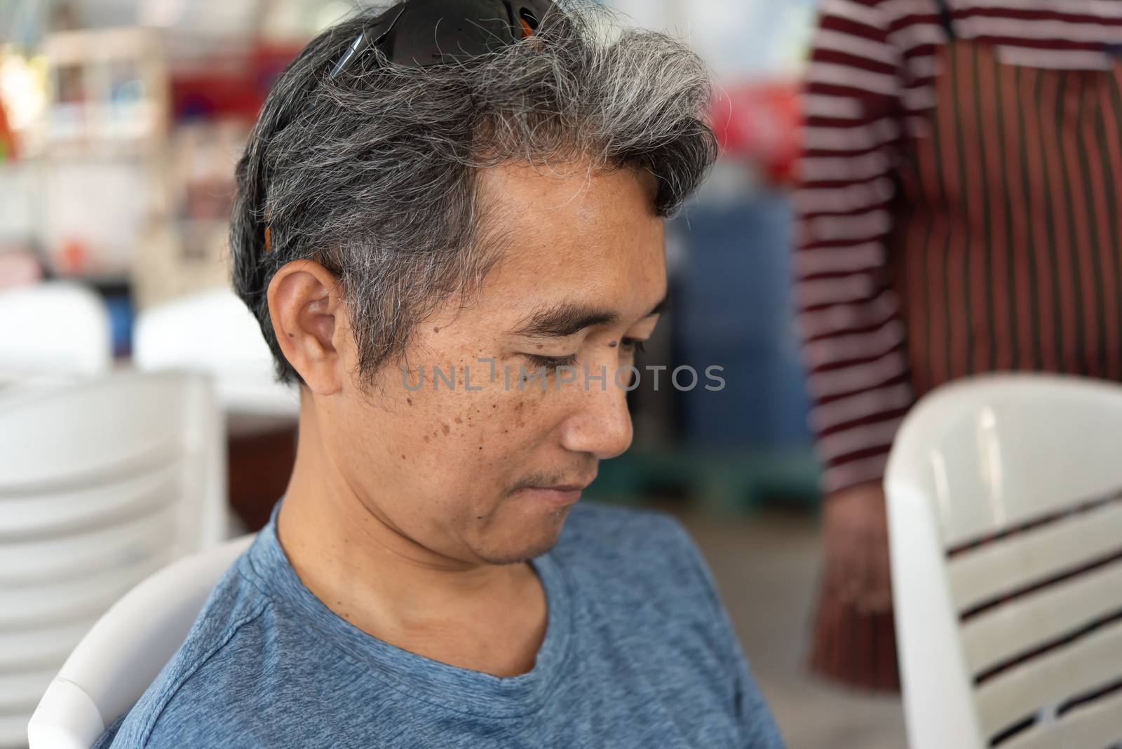 Man eating food on dining table in restaurant by PongMoji