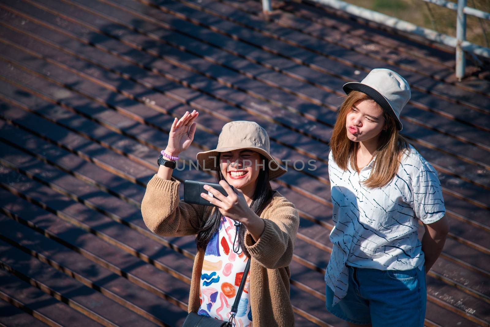 Asian pretty cute women with hat relax and use smartphone at seaside city landscape viewpoint on mountain with happy and freedom emotion in concept travel, vacation, leisure in life