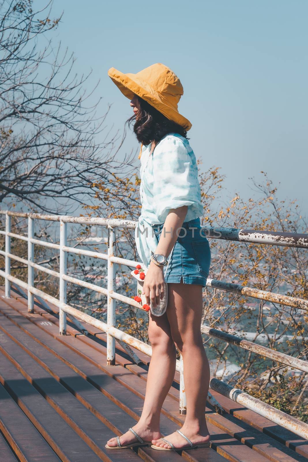 Asian pretty cute woman with hat relax at seaside city landscape viewpoint on mountain with happy and freedom emotion in concept travel, vacation, leisure in life