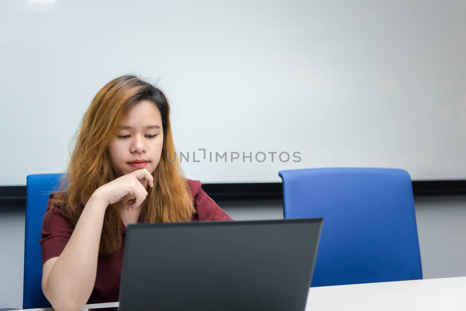 Woman working by laptop in office with thinking by PongMoji