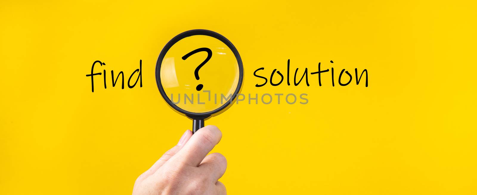 Magnifying glass with QUESTION MARK in focus on yellow background. concept of search and research.