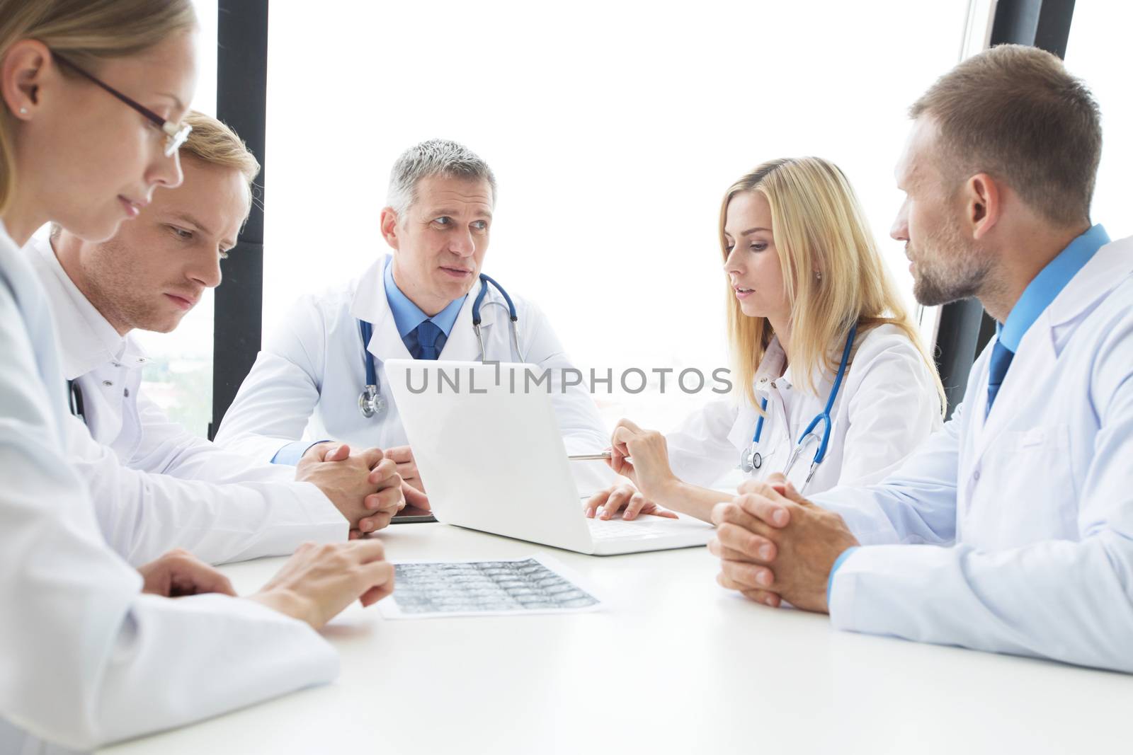 Team of experts doctors examining mri report on hospital office meeting