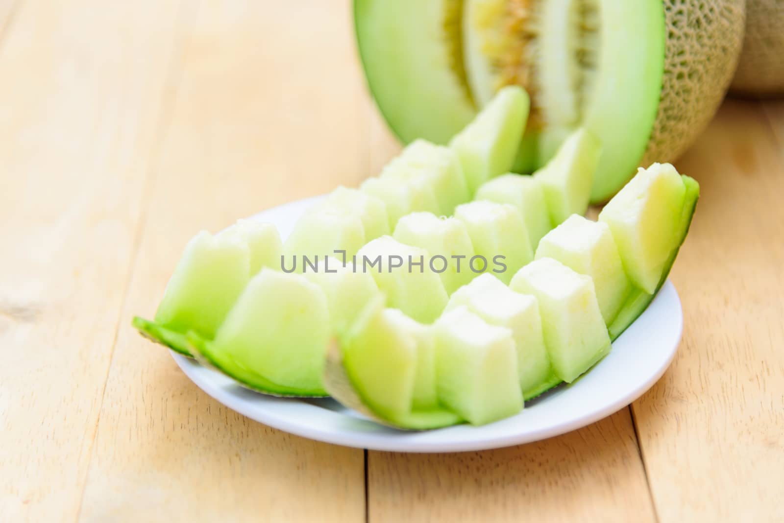 Fresh green melon on wood plate
