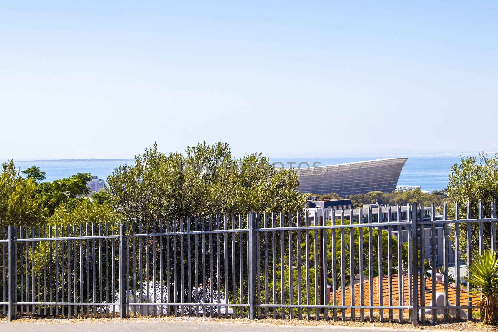 Cape Town Stadium behind fence in Cape Town. by Arkadij