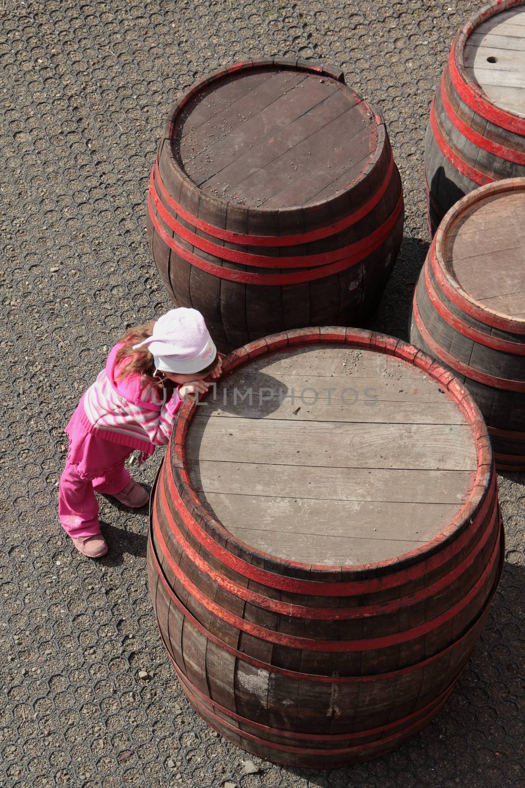 Sad, lonely child leaning on the barrel.