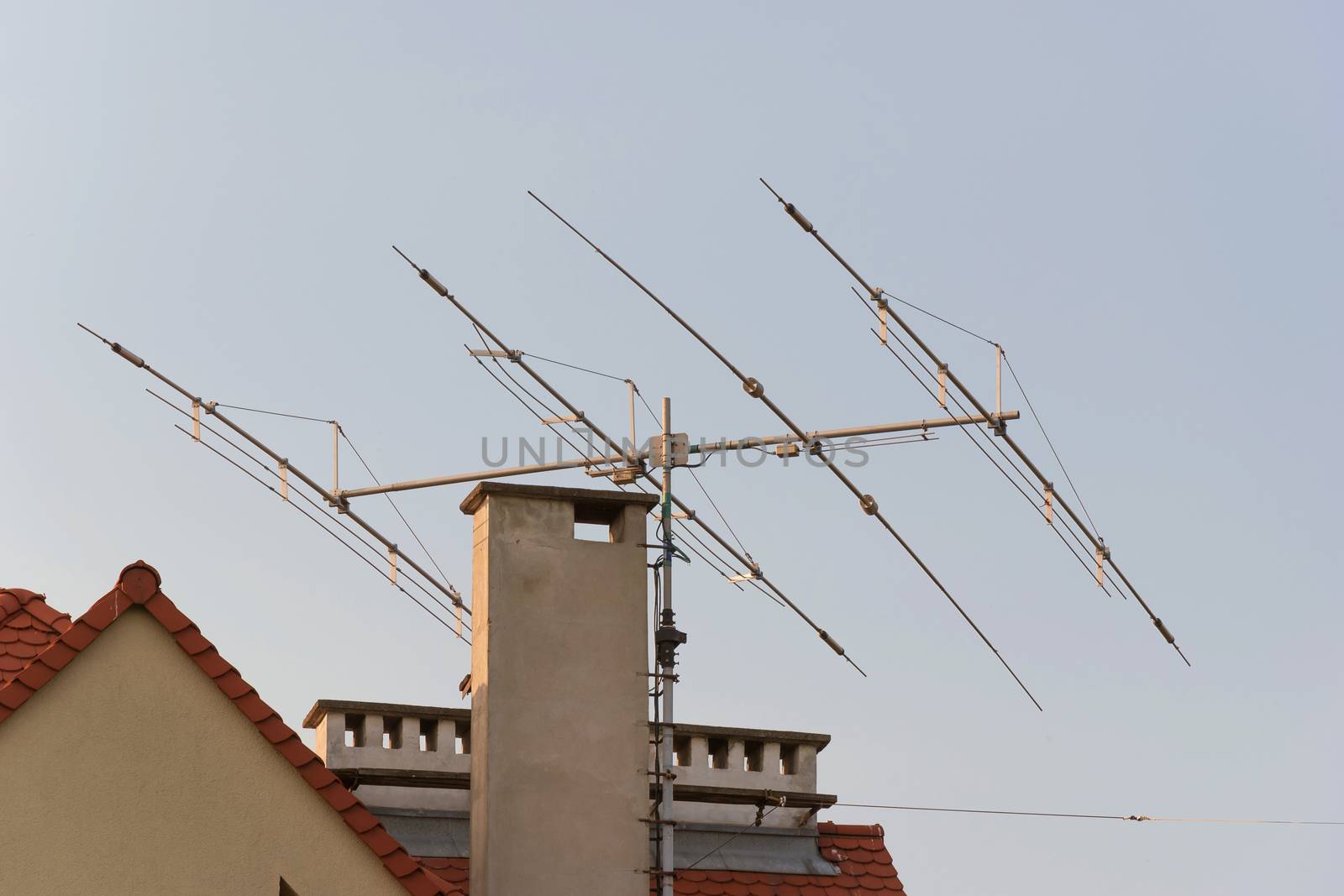Tv antenna on roof of home. Technology of broadcast television and radio on rooftop. Signal receiver. Tower of transmit media. Residential roofing with mast of analogue antena. urban   Photography 