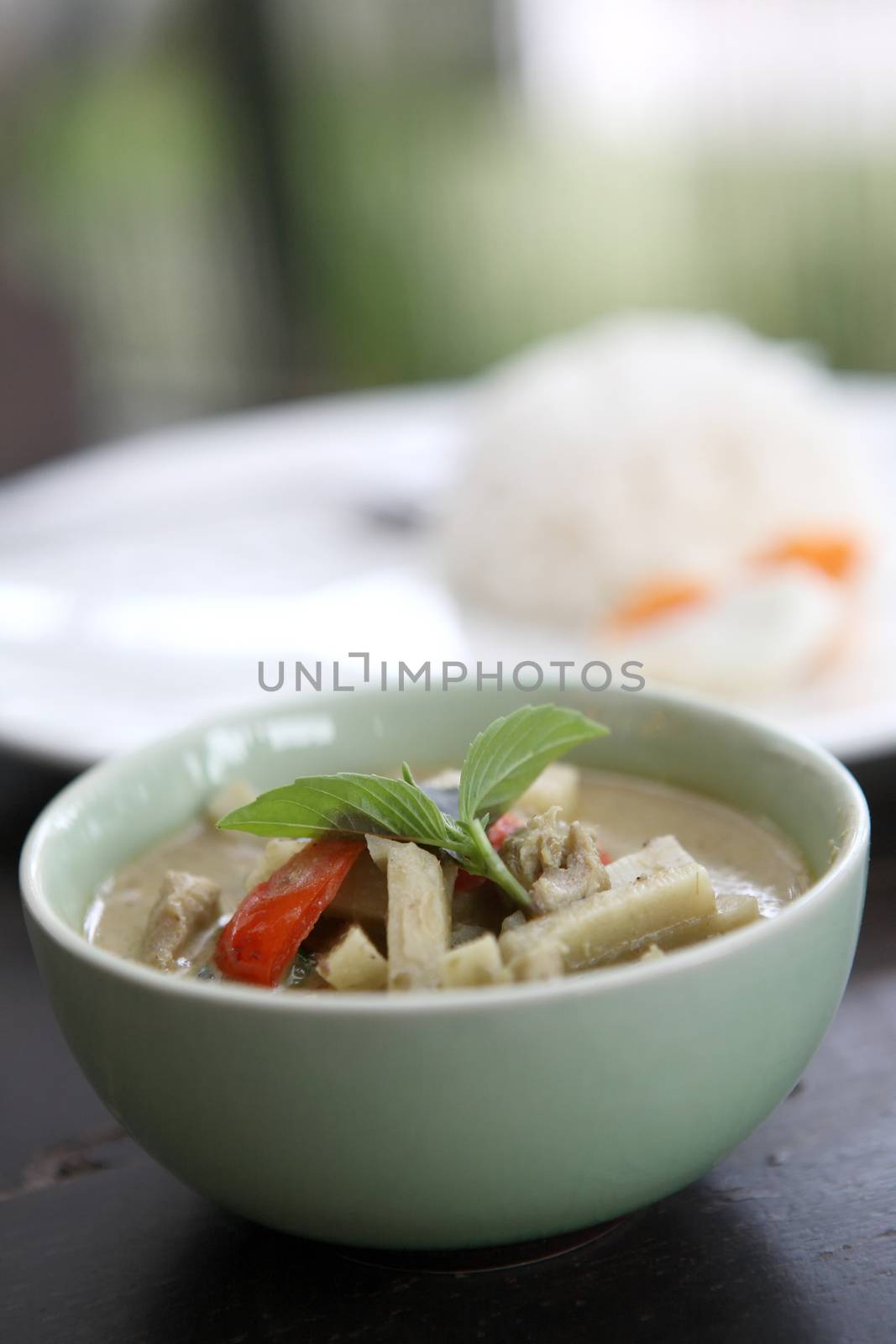 Thai food chicken green curry with rice in wood background by piyato