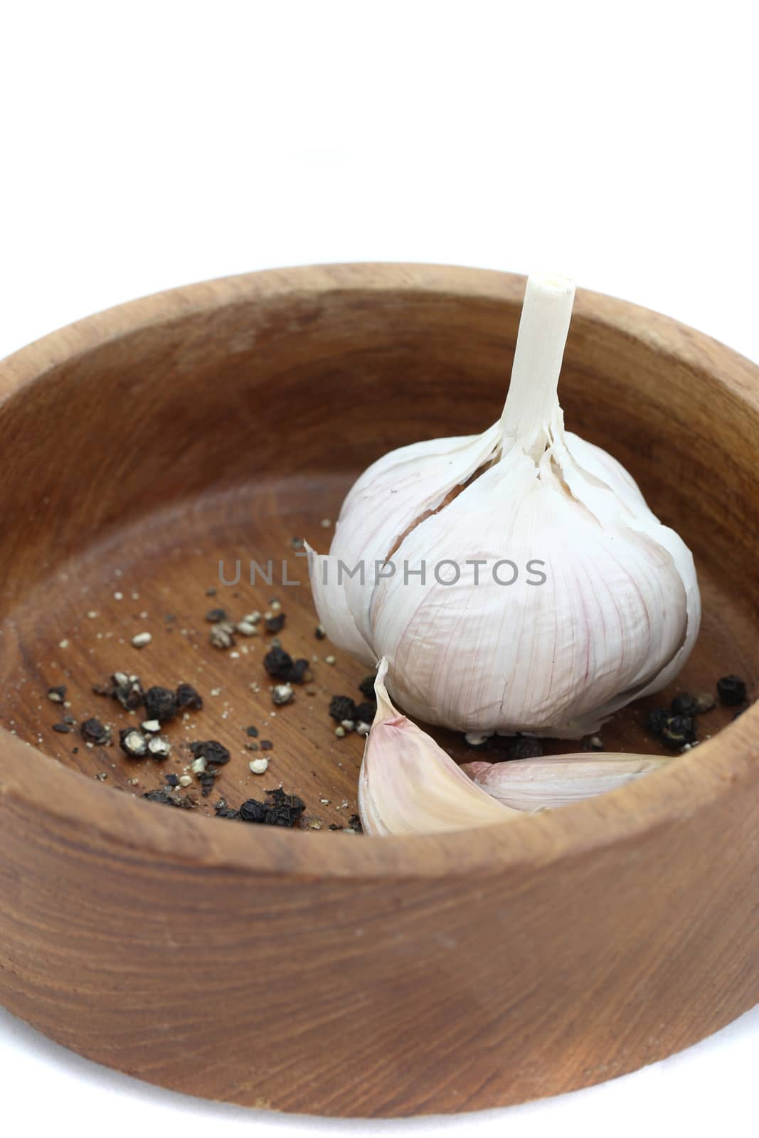 garlic and pepper on wood bowl isolated in white background