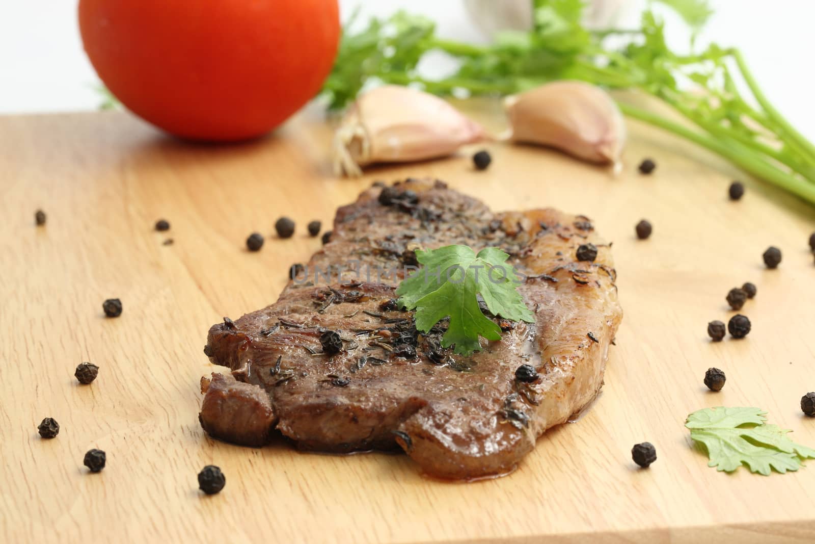 Grilled steak with vegetables on wood background