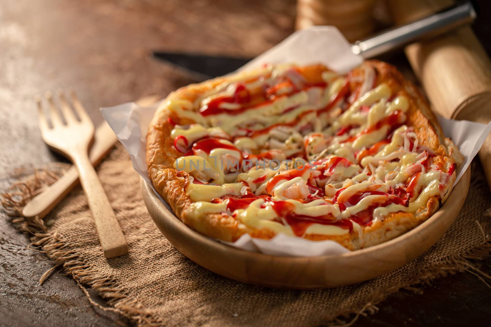 Close up of tasty homemade seafood topped pizza fusion food style on wooden tray.