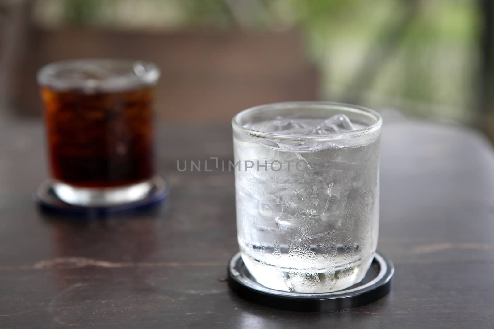 Glass with water and cola on wood background by piyato