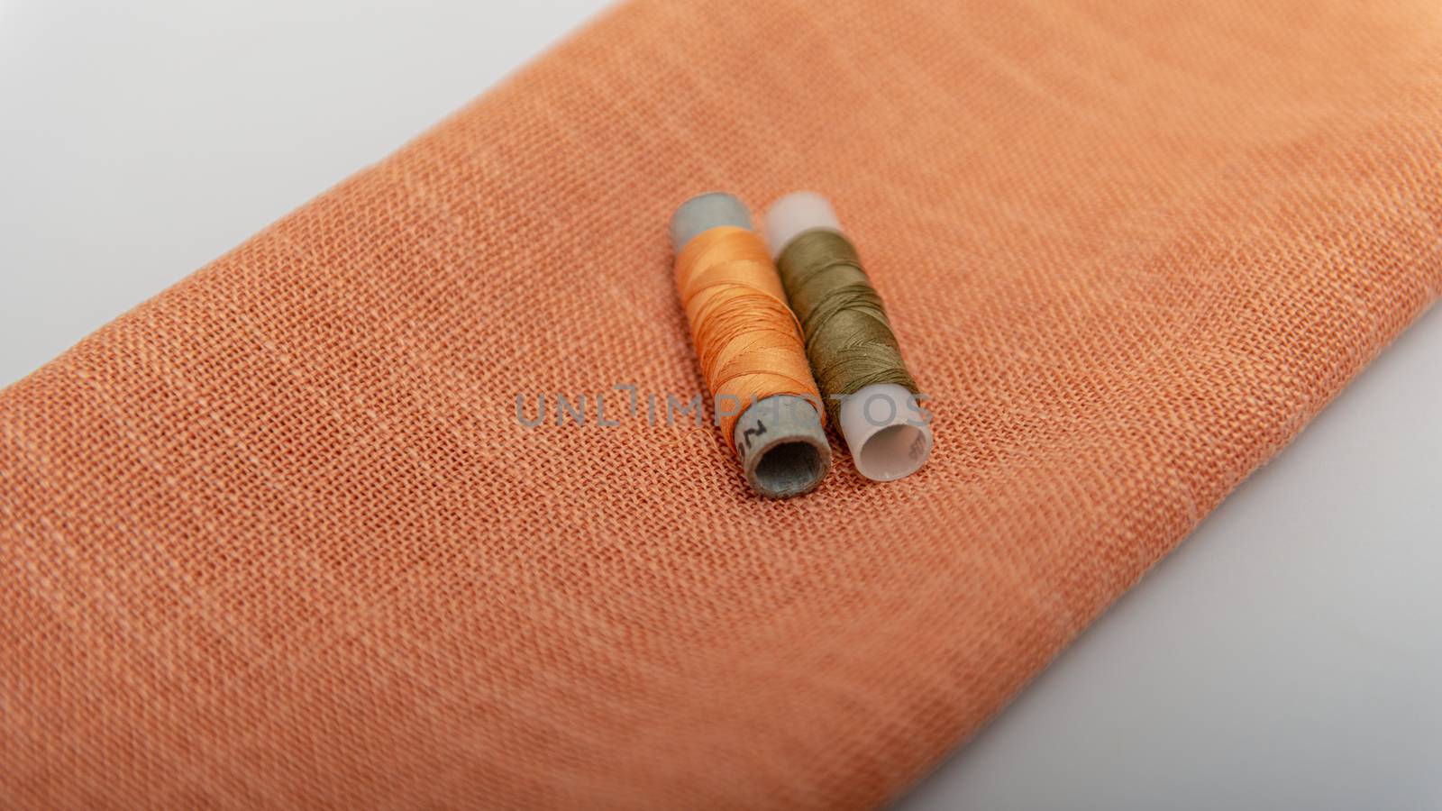 top view of color threads on the orange fabric by marynkin