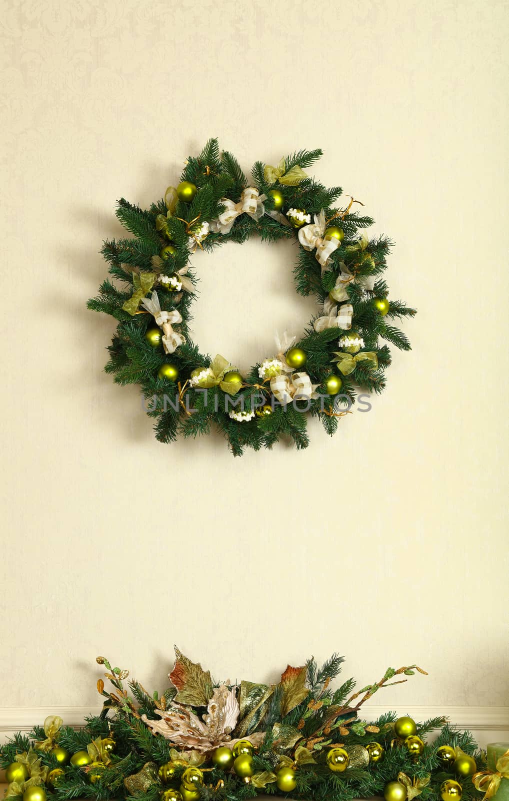 Close up green Christmas wreath decoration on beige wall, front view