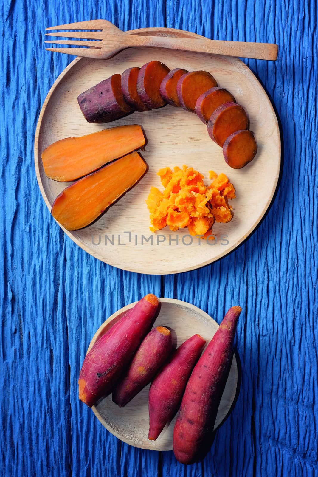 Sweet Potato on wooden cutting board with blue wood background