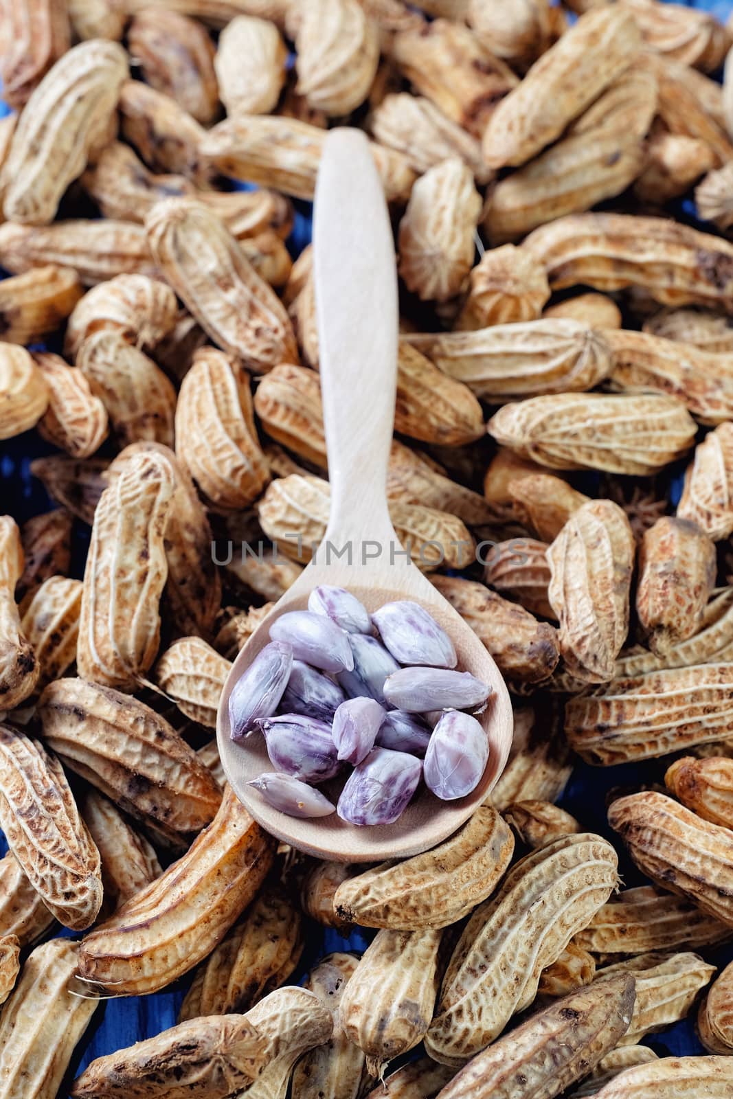 Peanuts on blue wood background by Surasak