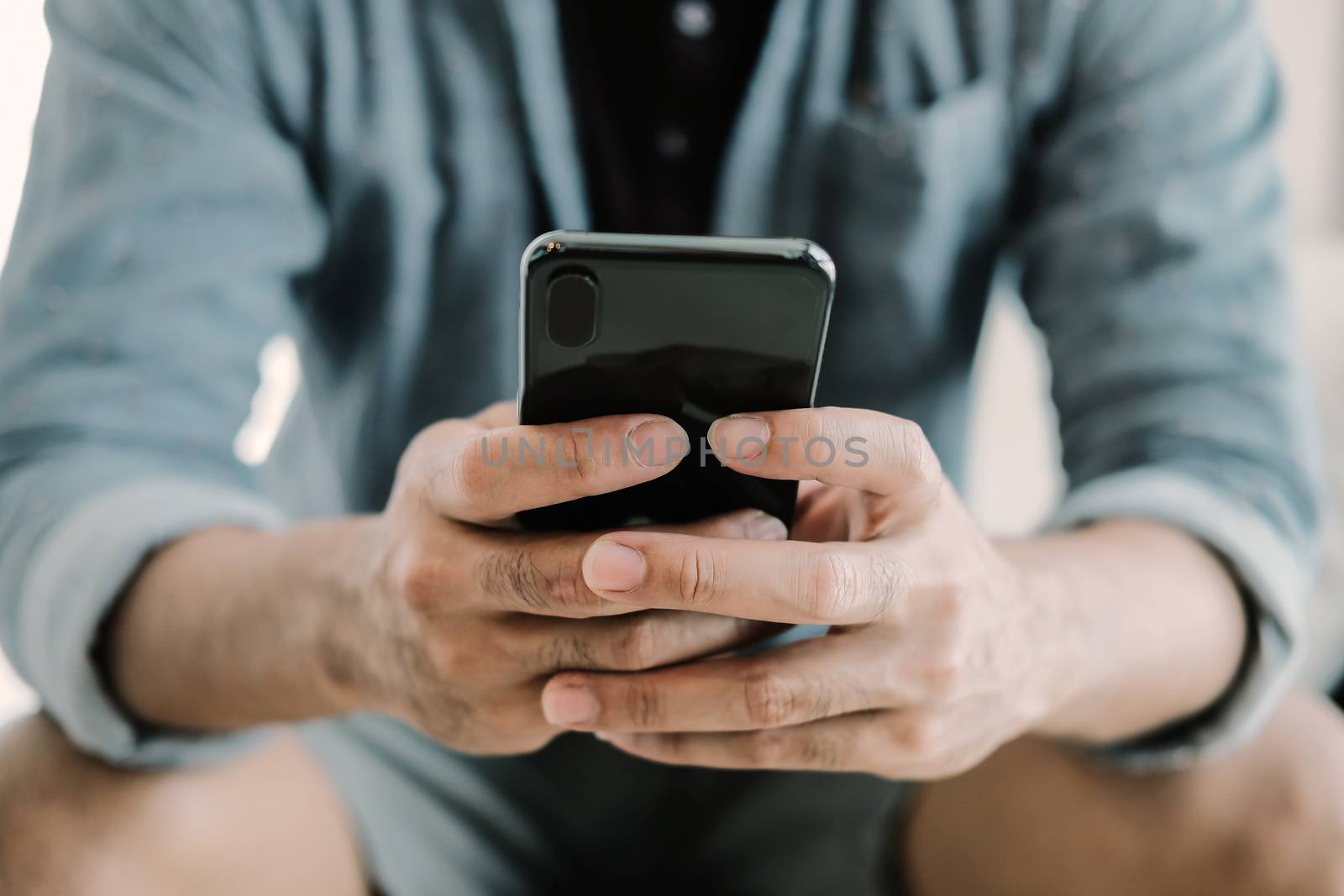 Close up man using smart phone at home.