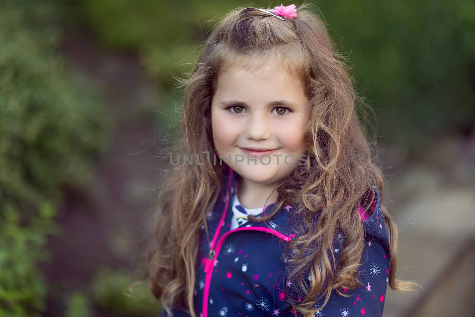 Closeup portrait of happy cute little girl with curly golden hair