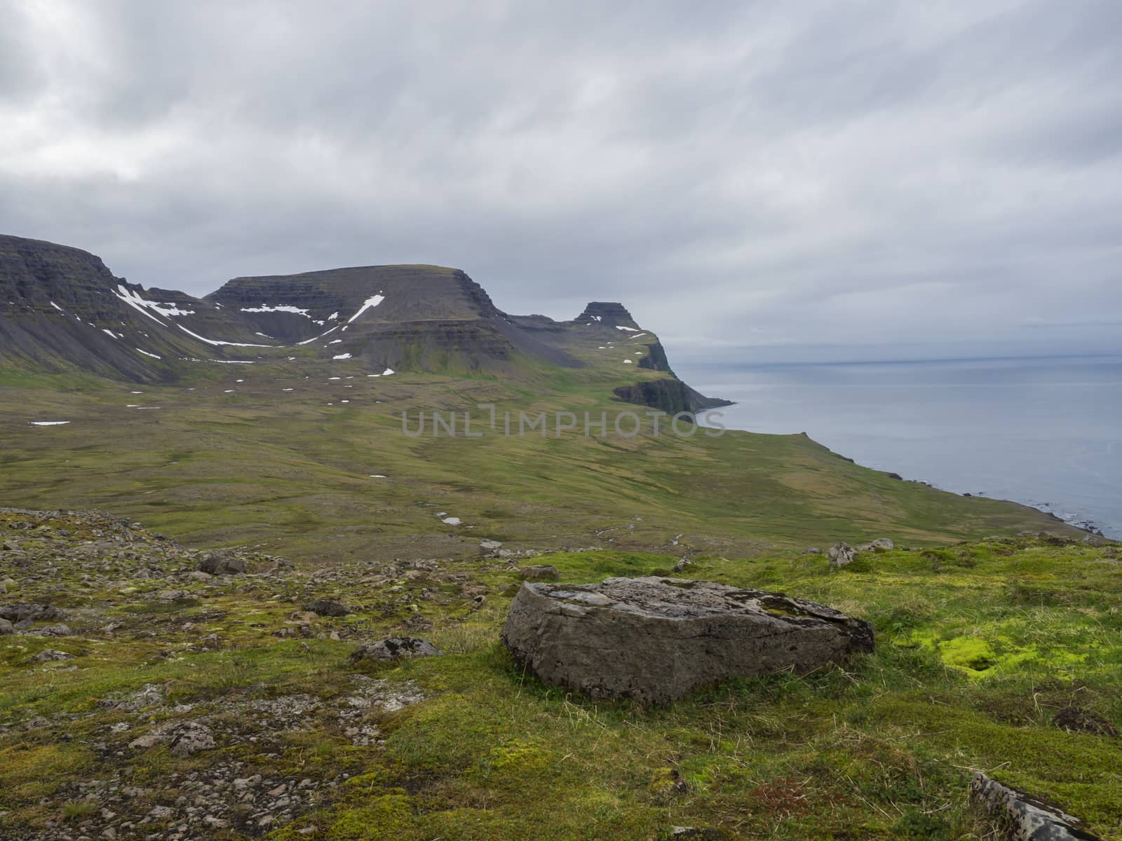 beautiful snow spotted green cliffs and blue sea horizon with bi by Henkeova