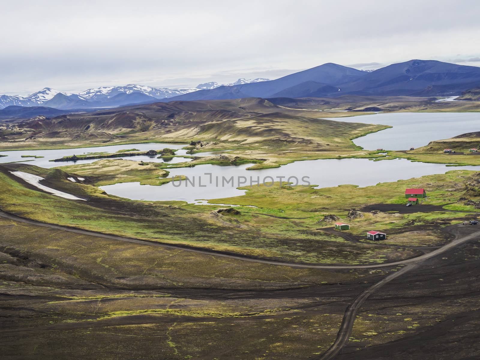 veidivotn fishing hut and cabin, landscape with Colorful crater lake and volcanic snow covered mountains in Veidivotn lakes, popular fishing area for local, central Iceland highlands in the middle of black lava desert