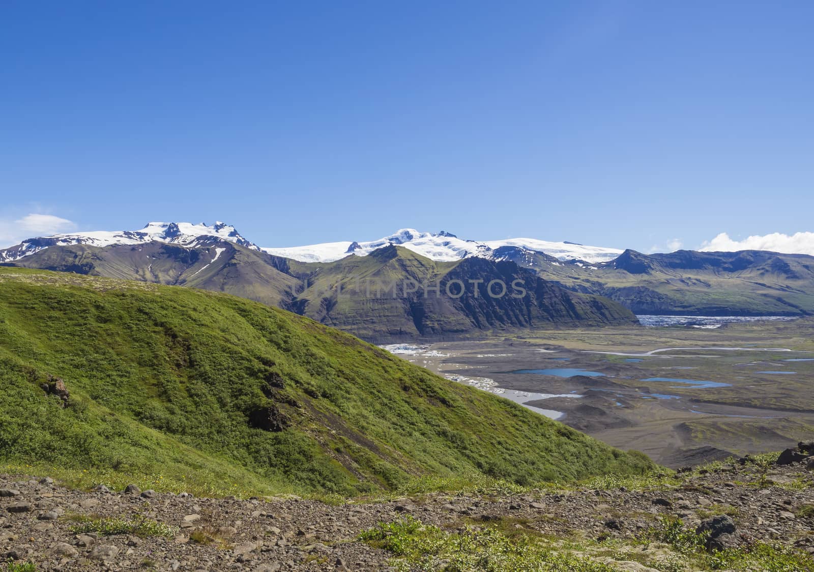 View on glacier lagoon with icebergs and tongue of Skaftafellsjokull, colorful rhyolit mountains in Skaftafell by Henkeova
