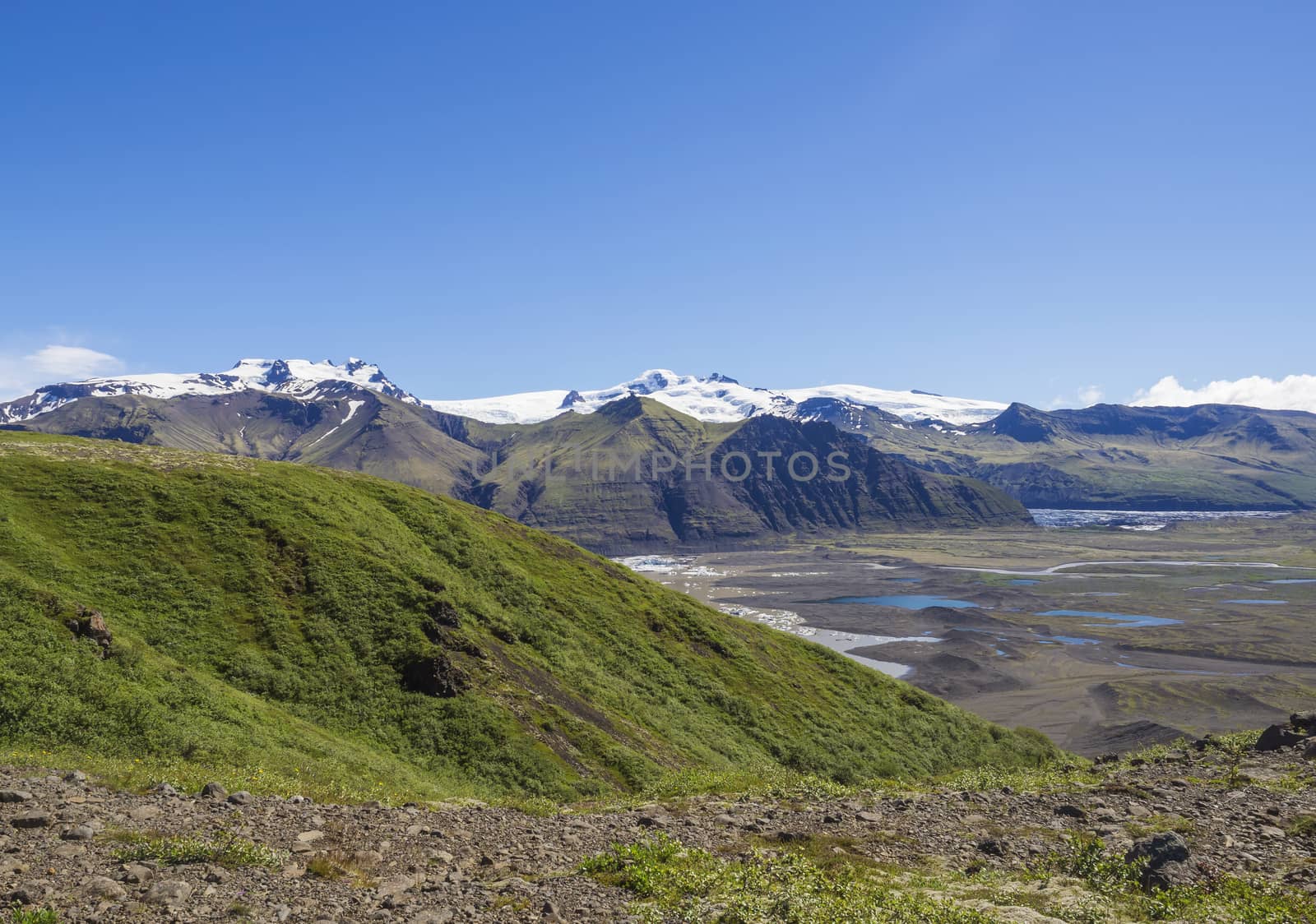 View on glacier lagoon with icebergs and tongue of Skaftafellsjokull, Vatnajokull spur, valley Morsardalur river and colorful rhyolit mountains in Skaftafell national park, Iceland