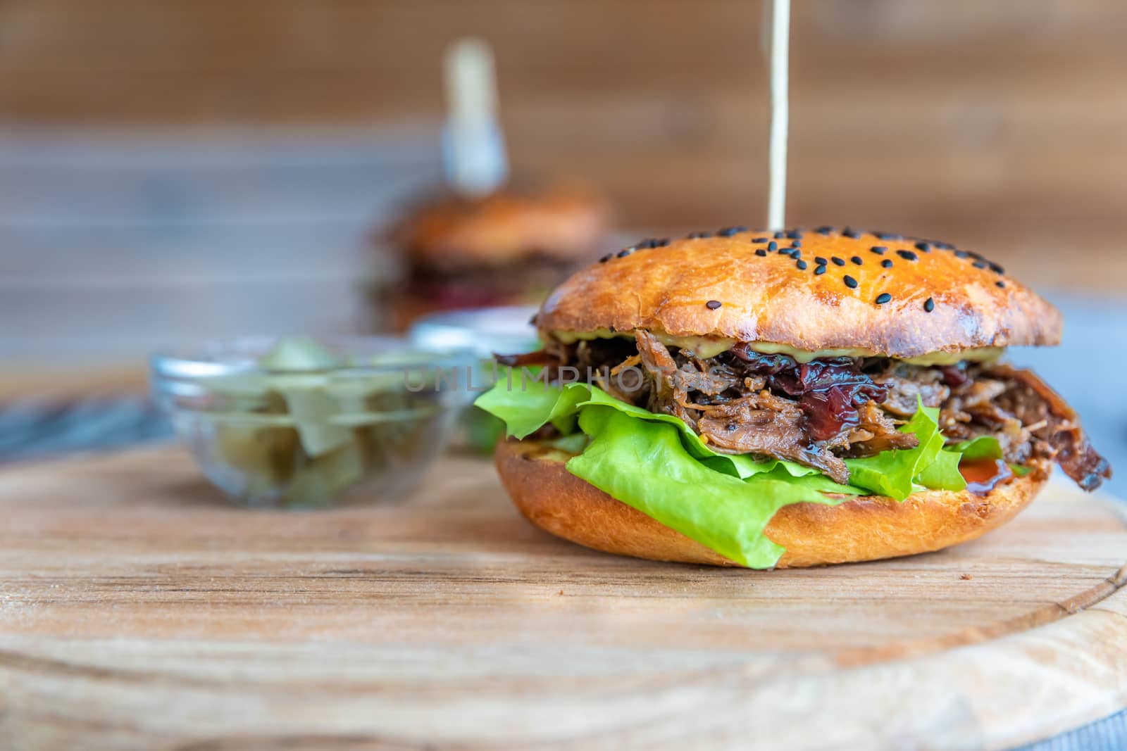 hamburger with shredded beef on a wooden board