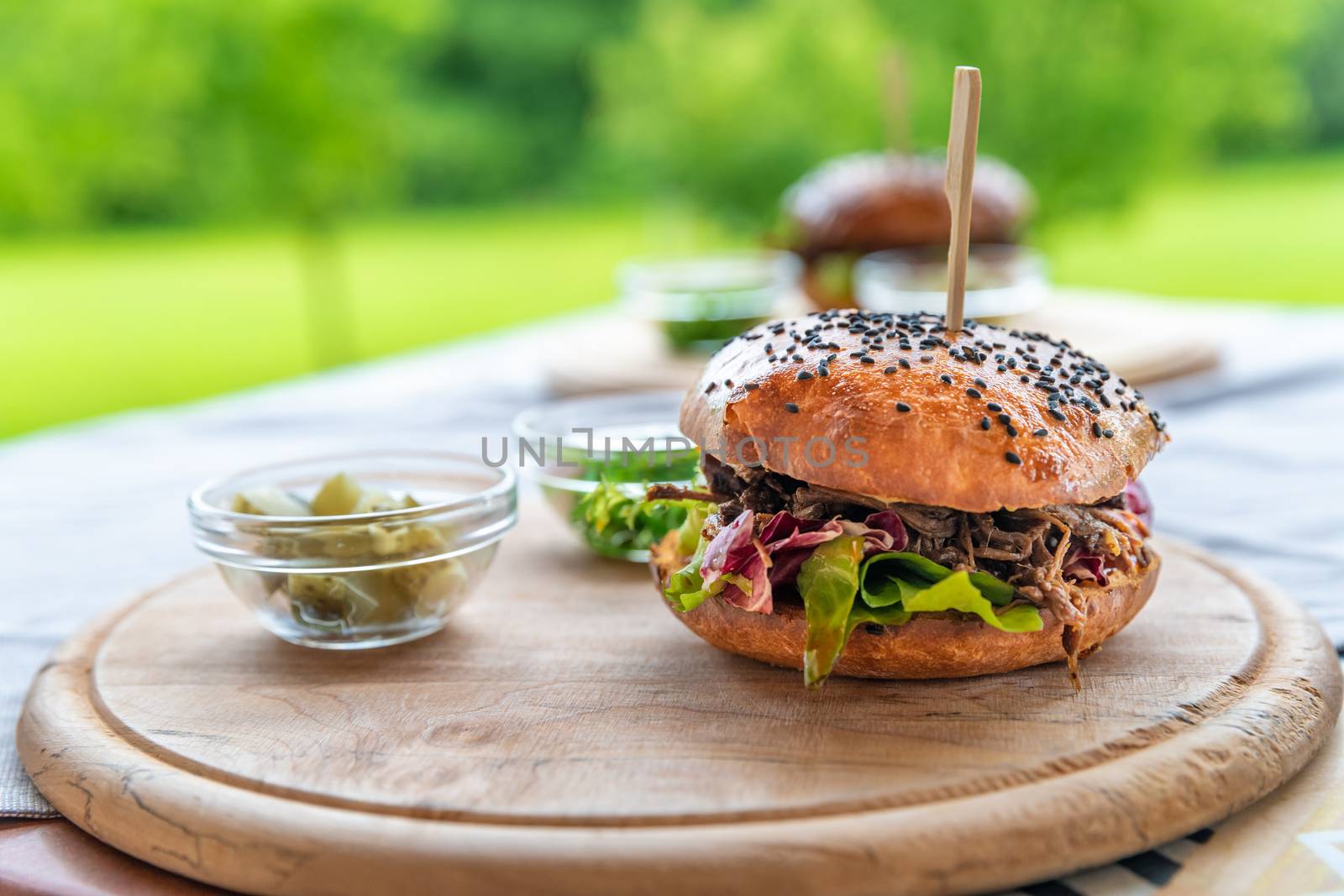 burger on a wooden board on the terrace of the restaurant.
