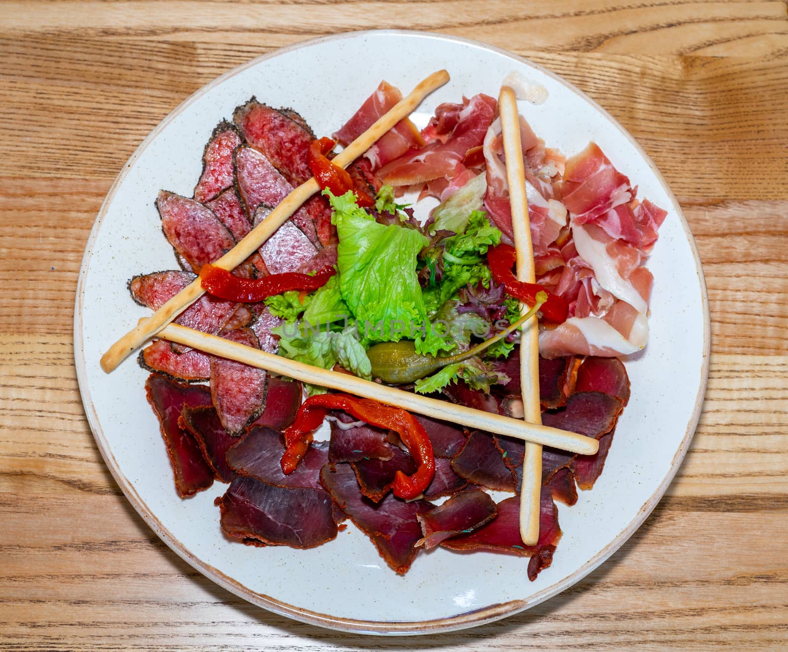 Trio of dried delicacies. Basturma, prosciutto, sausage flat. Plate with delicacies by Serhii_Voroshchuk