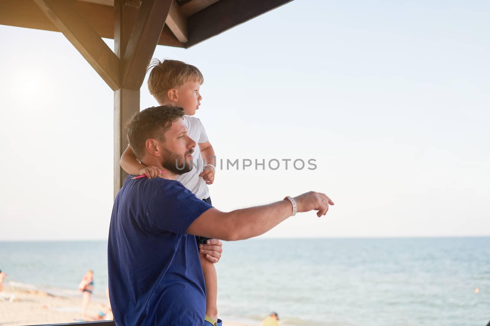 Father son together outside showing finger sea horizon back Man child spending time vacation enjoying summer Family with one child. Caucasian person beach