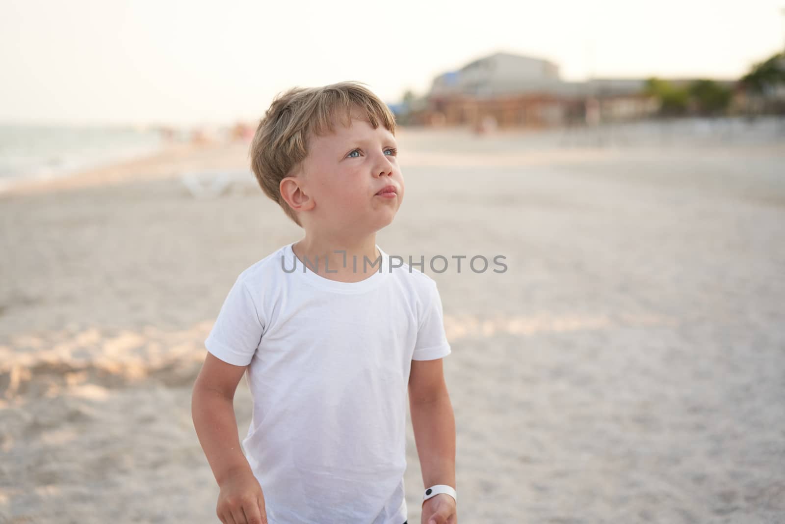 Caucasian boy standing beach. Childhood summertime. Family vacation with one child.