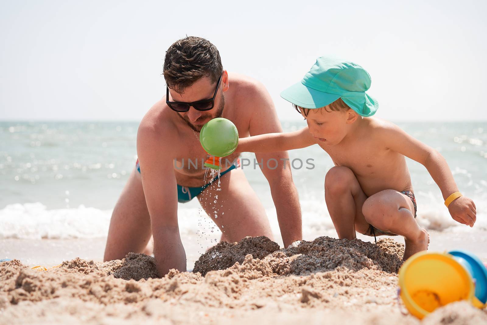 Father son together summer vacation playing sand sea beach Dad kid enjoyment togetherness weekend activity. Family with one child lifestyle. Caucasian male play