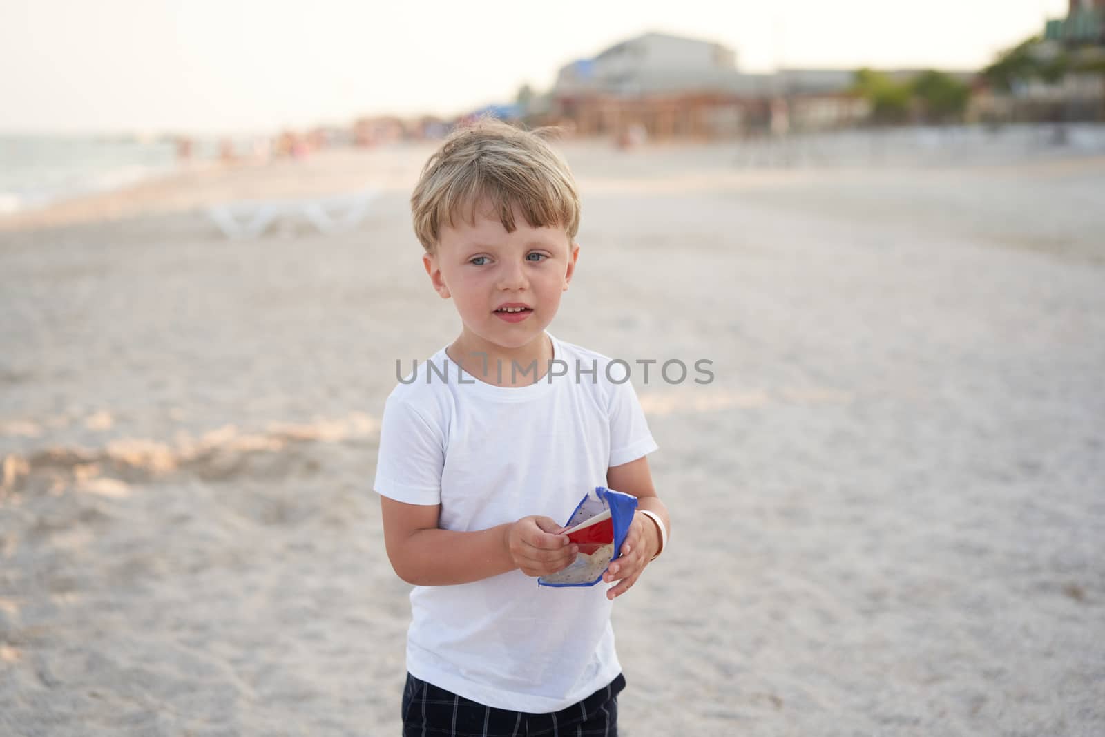 Caucasian boy standing beach. Childhood summertime. Family vacation by andreonegin