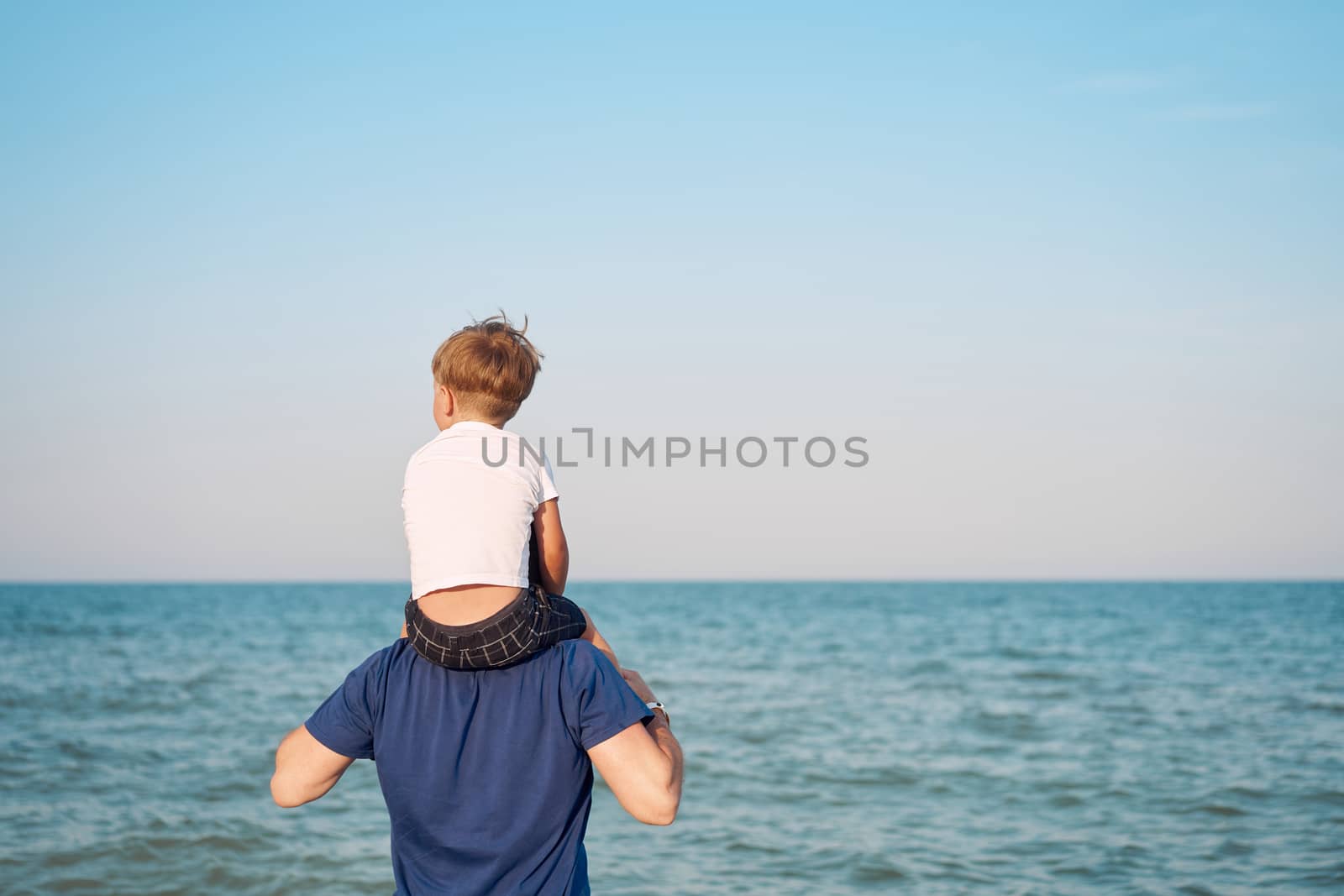 Father son together outside sea horizon Unrecognizable Man child spending time vacation enjoying summer Family with one child. Caucasian person beach Little boy sit on man shoulders