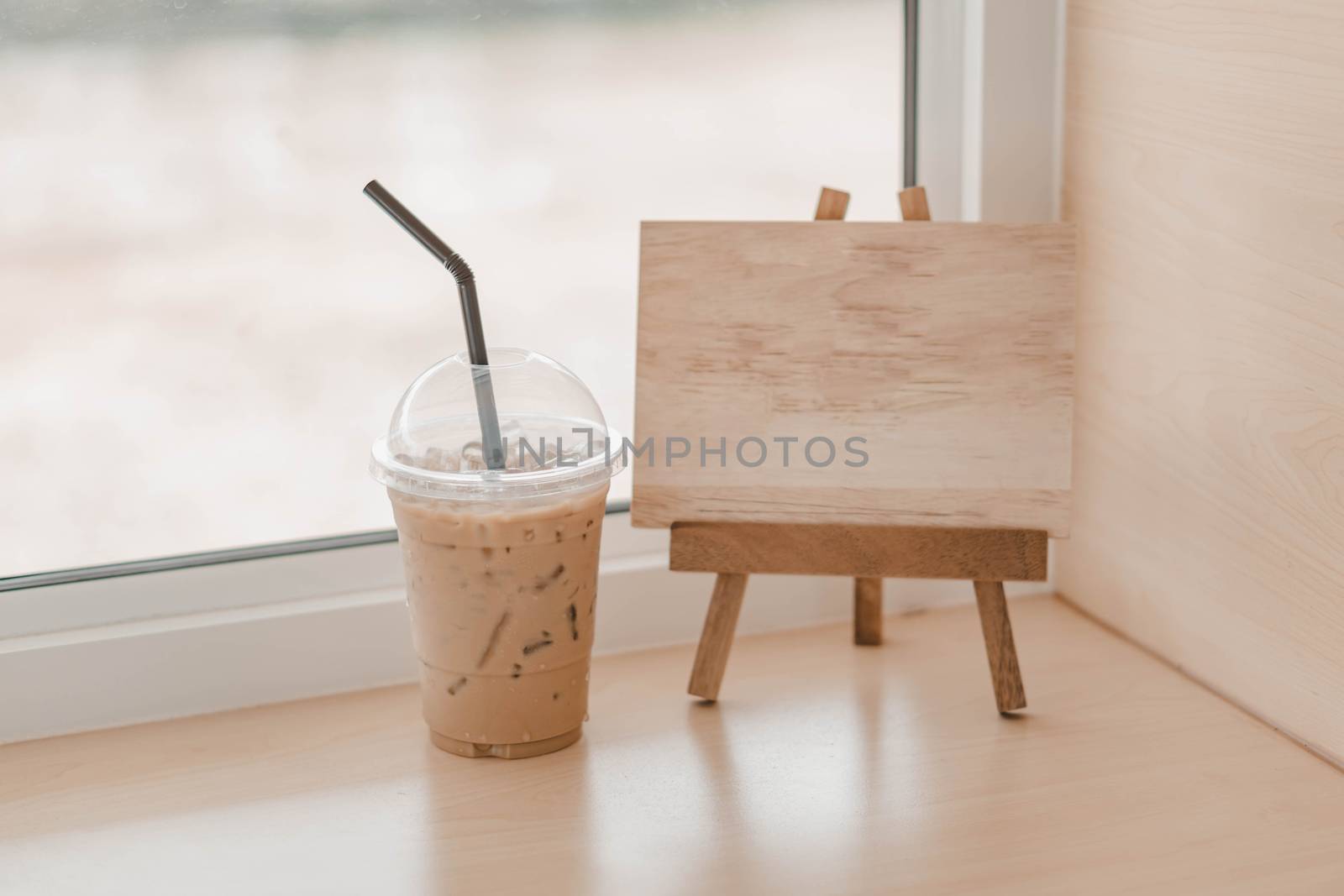 Closeup glass of ice coffee and empty wooden sign for text in th by pt.pongsak@gmail.com