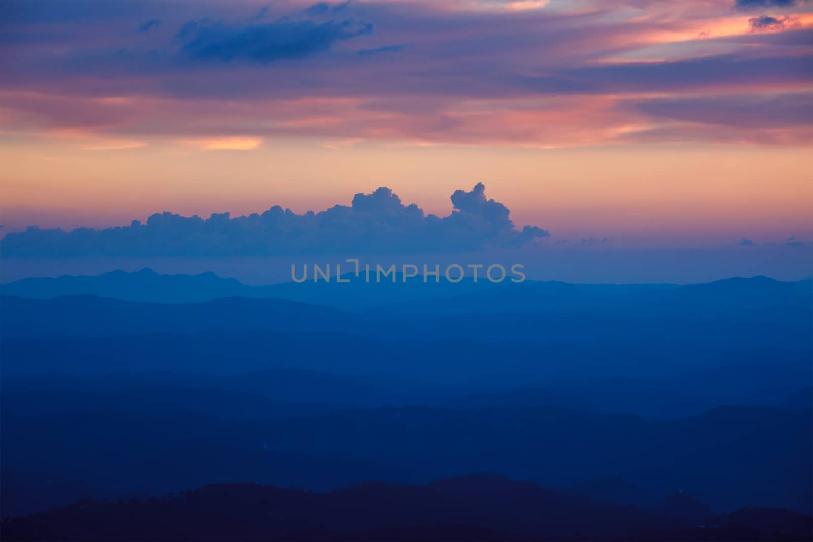 Silhouettes of hills in valley on sunset. Pothamedu viewpoint, Munnar, Kerala, India