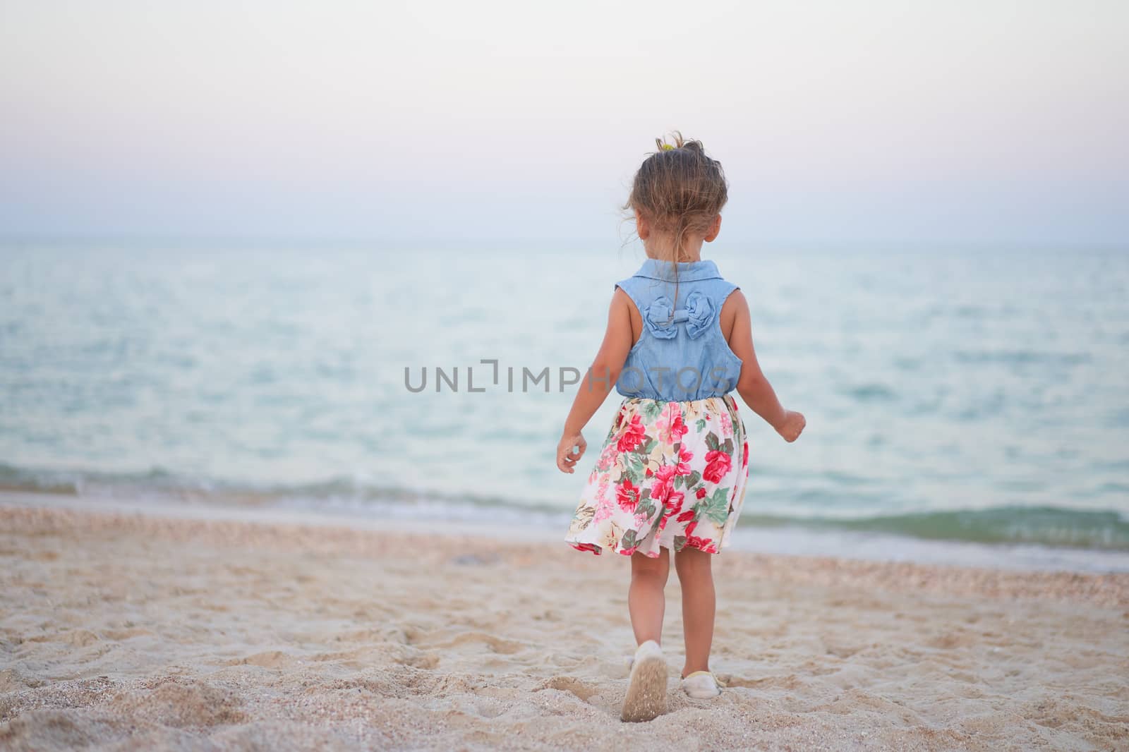 Child playing sand beach Little girl play sad alone summer family vacation Caucasian female 3 years old dressed denim near sea water