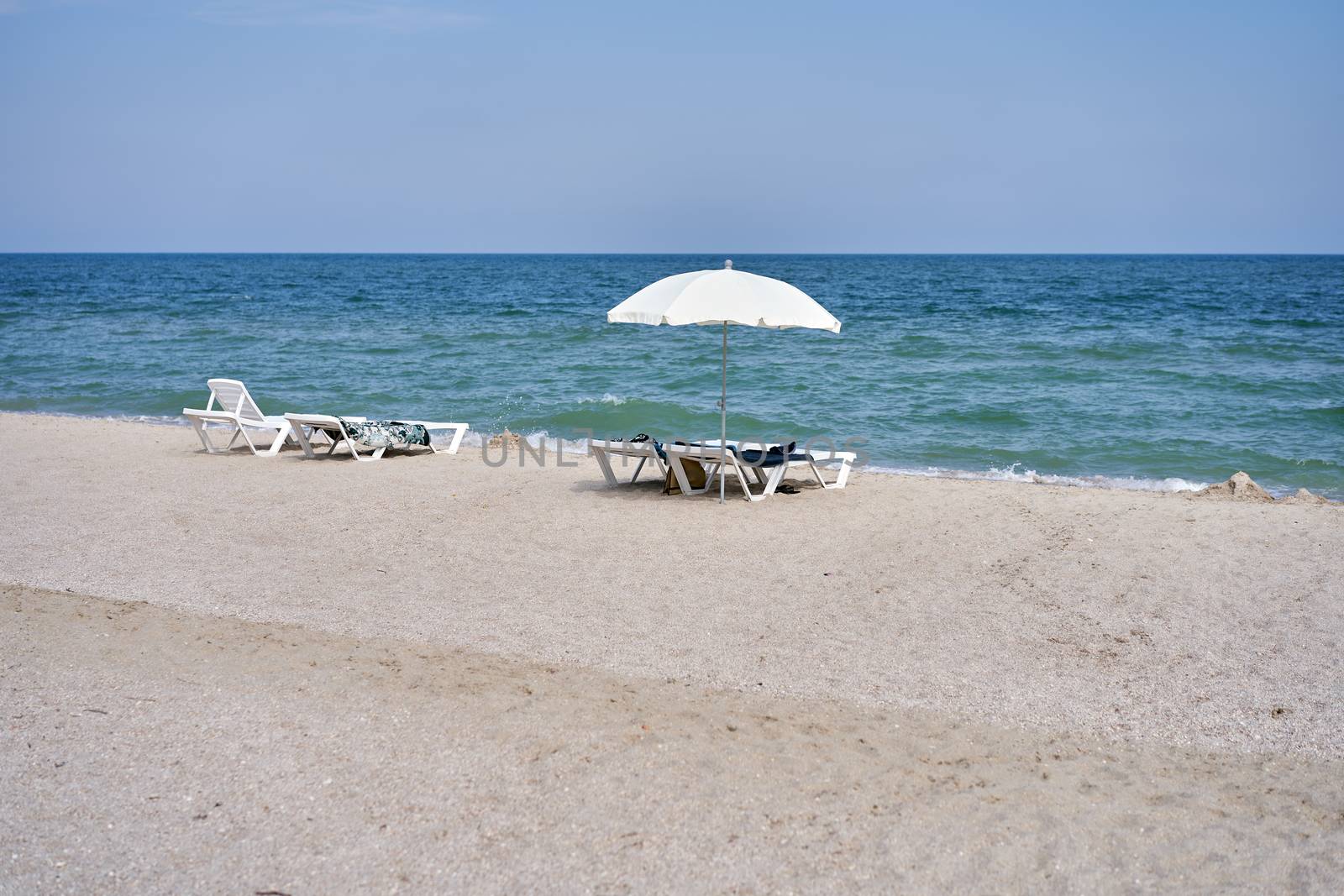 Empty relax white sunbed umbrella Lifestyle sea beach chair, relaxation, lounge Few tourists have a bad season.