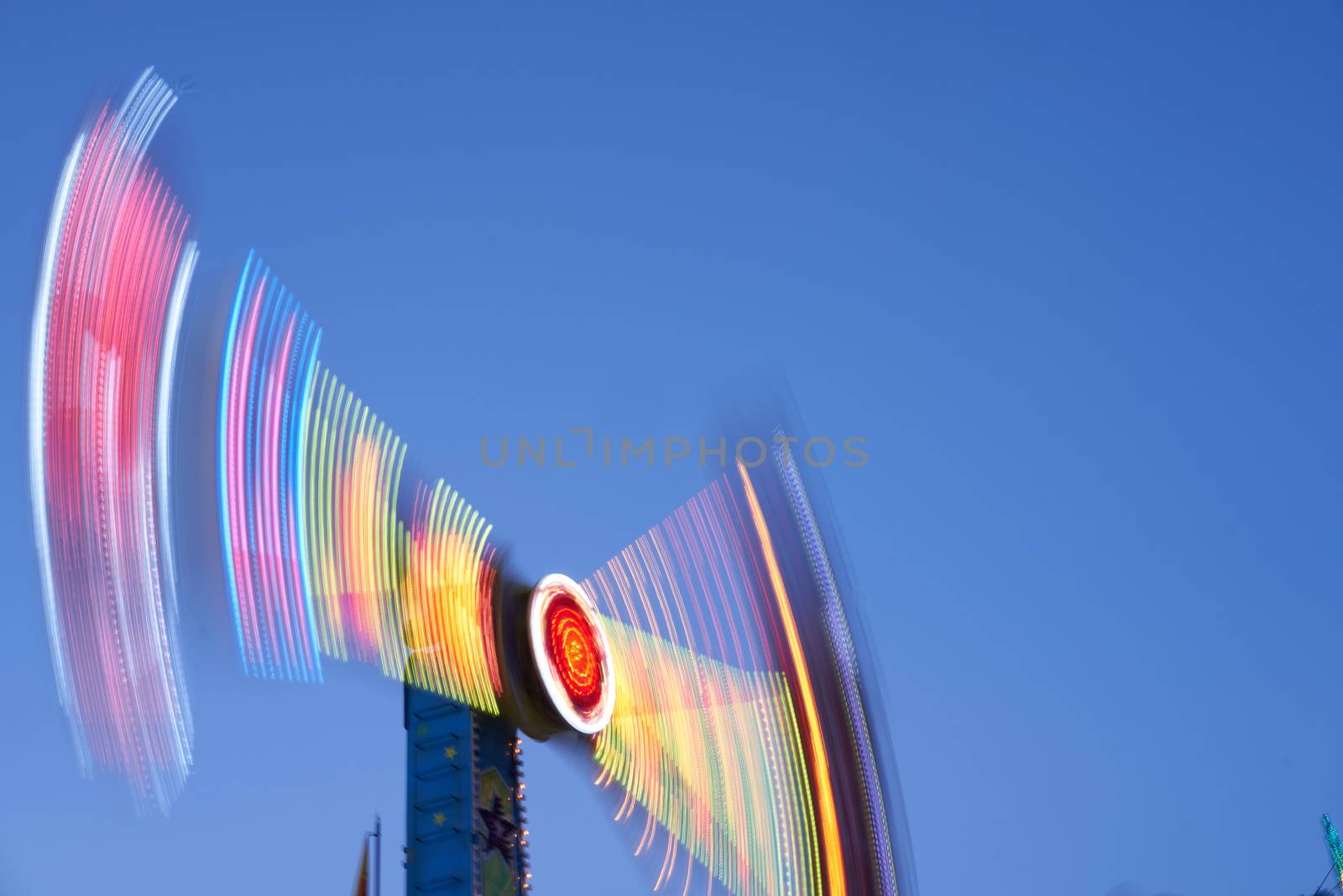 Amusement park blurred effect. Abstract illuminated background Spinning defocused carnival carousel long exposure shooting