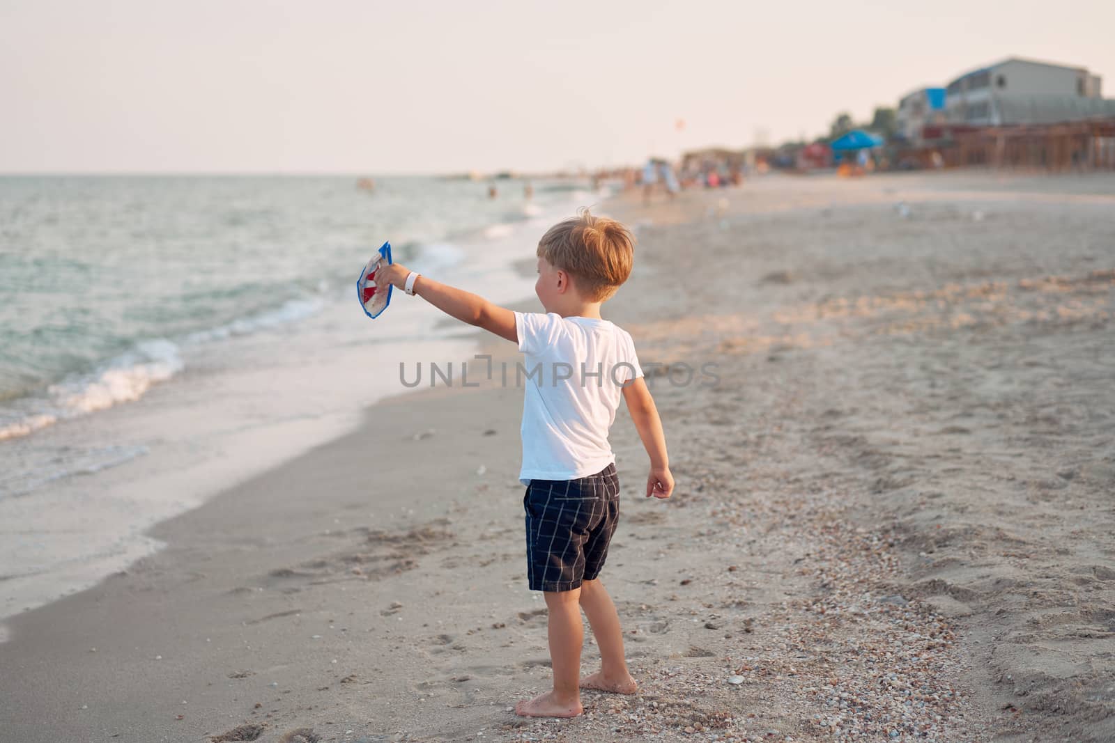 Caucasian boy standing beach. Childhood summertime. Family vacation by andreonegin