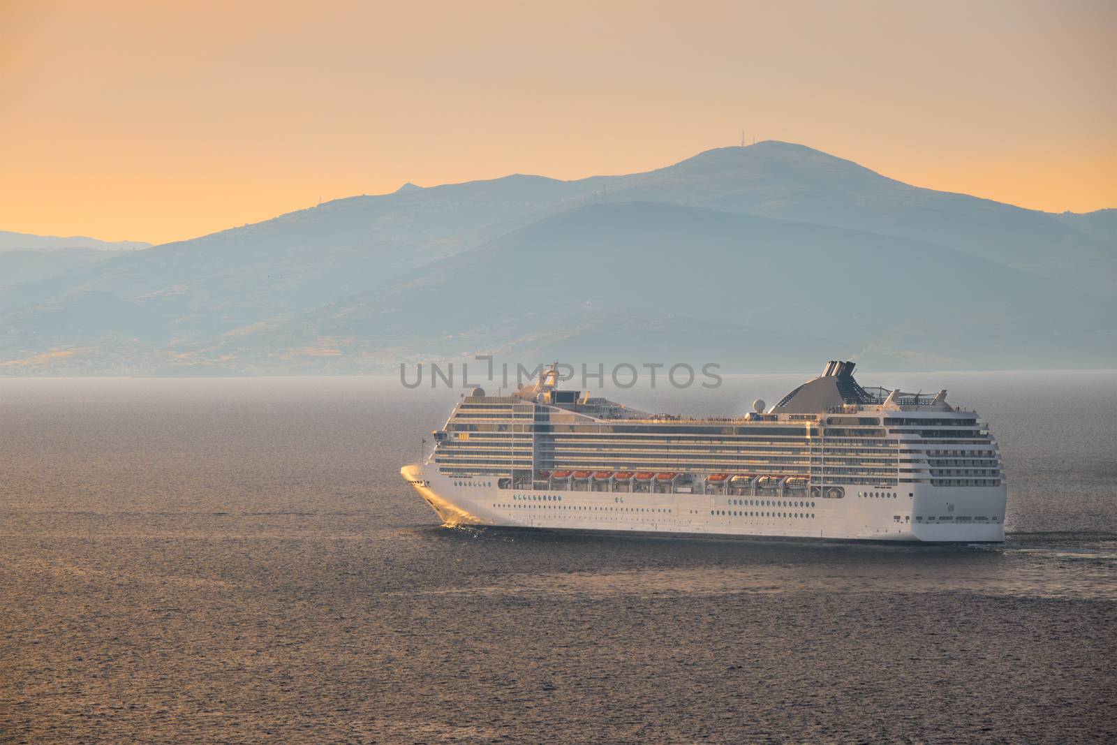 Cruise ship in Aegean sea on sunset by dimol
