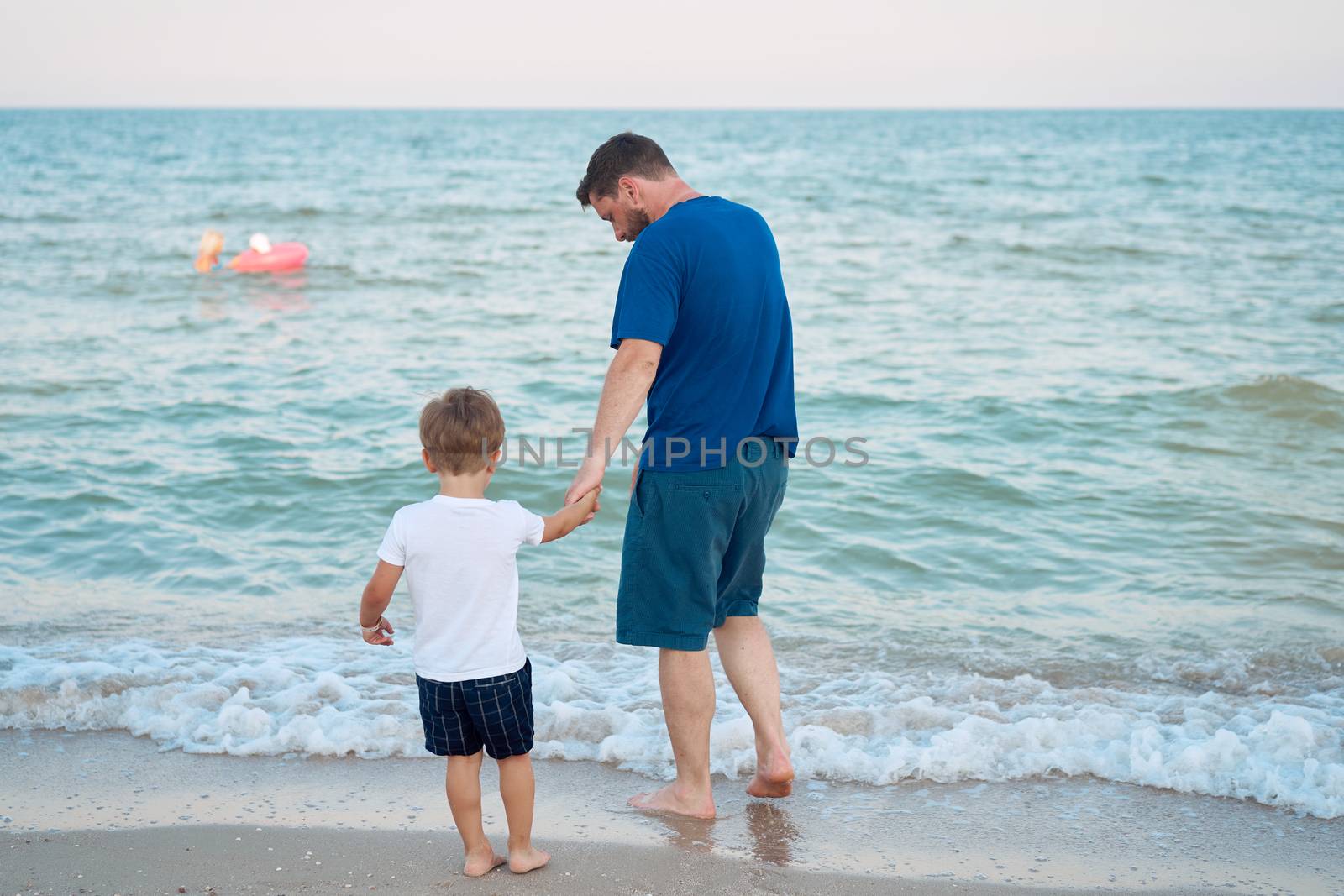 Father son spending time together sea vacation Young dad child little boy walking beach by andreonegin
