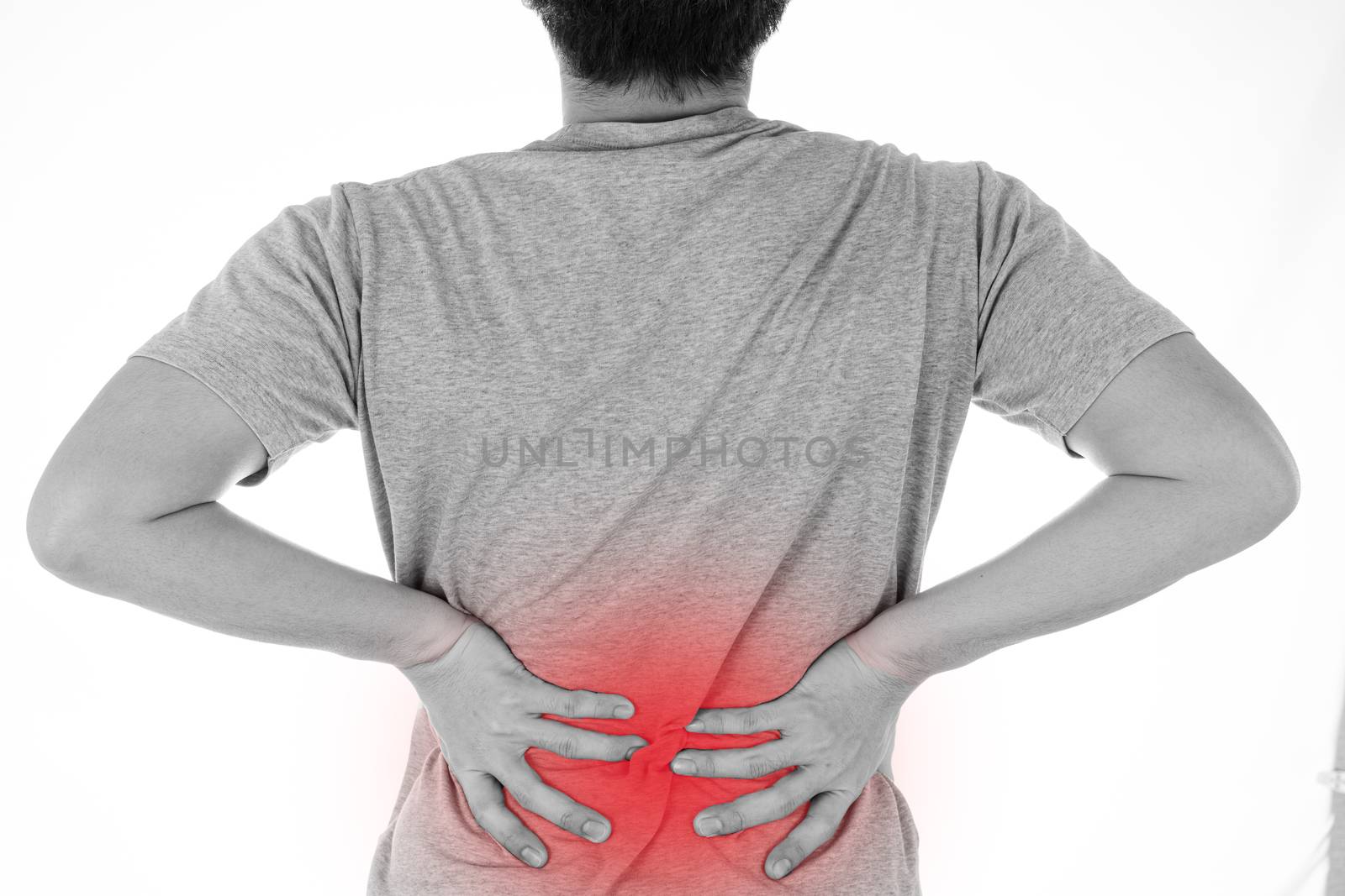 Black and white shot of man feeling exhausted and suffering from waist and back pain and injury on isolated white background with red spot. Health care and medical concept.