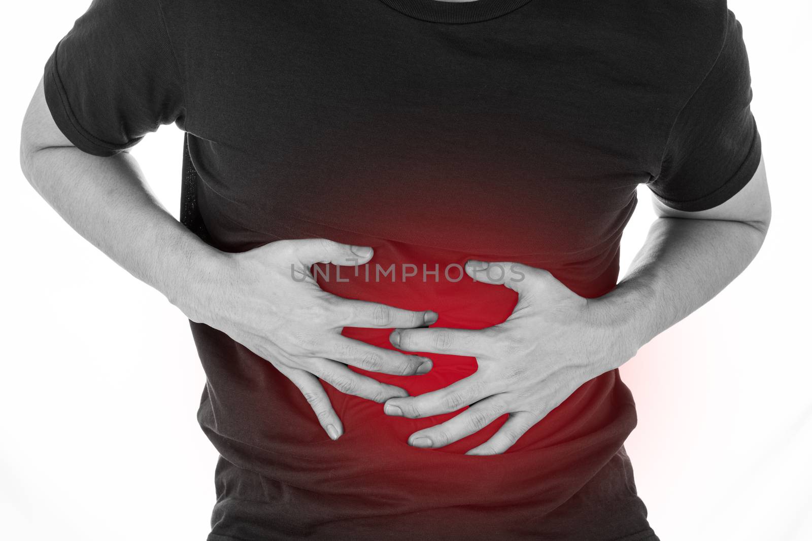 Black and white shot of man feeling exhausted and suffering from stomach pain and injury on isolated white background with red spot. Health care and medical concept.