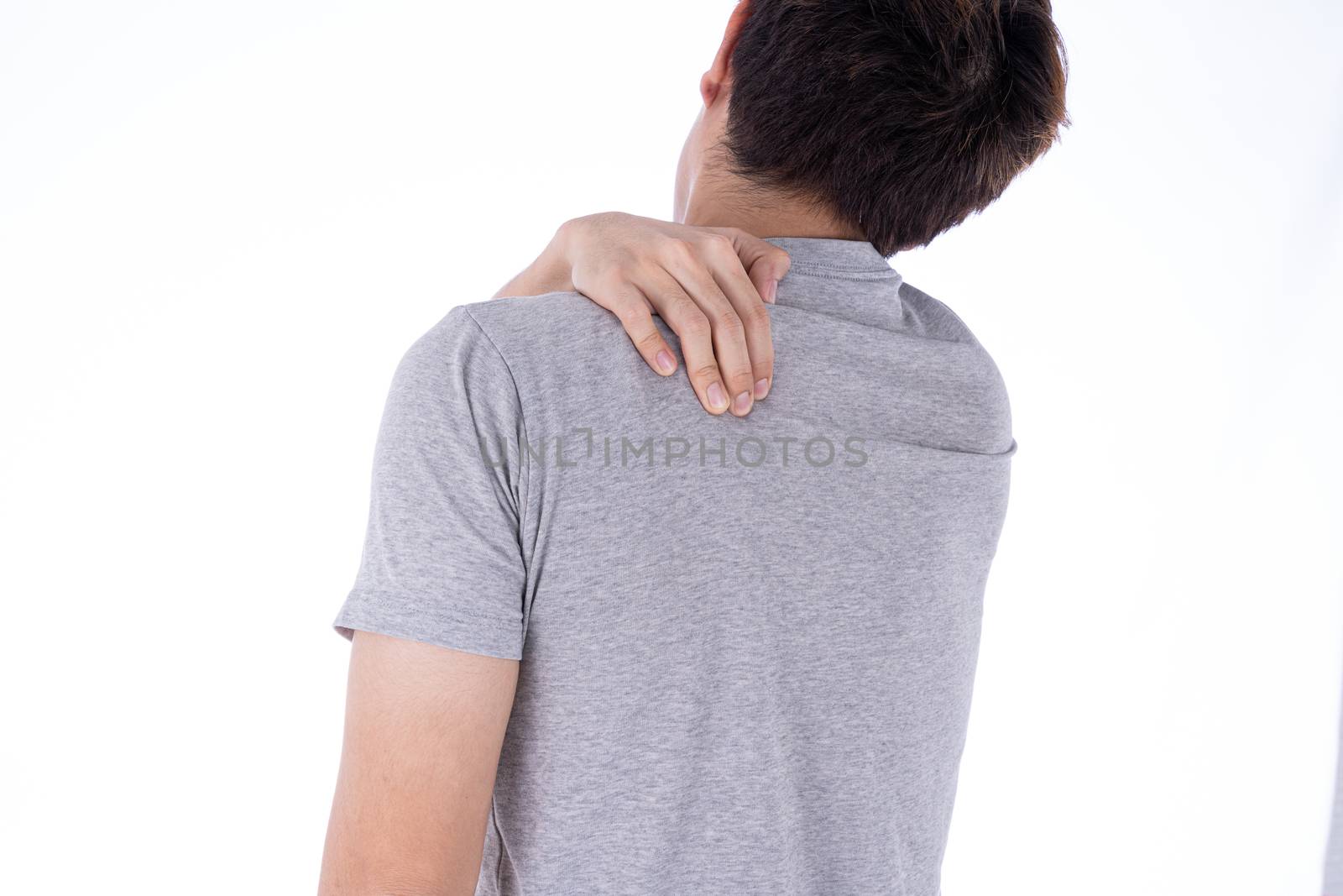 A man feeling exhausted and suffering from shoulder and neck pain and injury on isolated white background. Health care and medical concept.