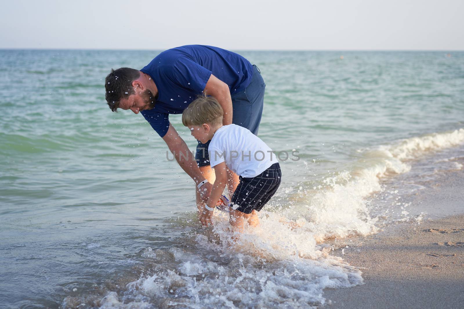 Father son spending time together sea vacation Young dad child little boy walking beach by andreonegin