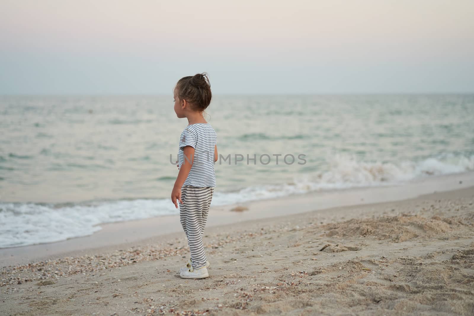 Child playing sand beach Little girl play sad alone summer family vacation by andreonegin